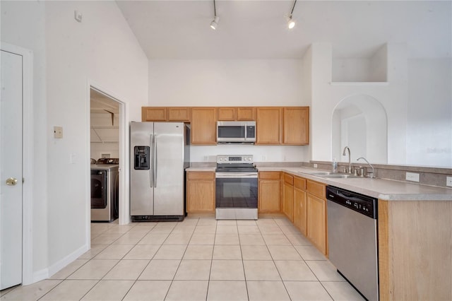 kitchen featuring light tile patterned floors, stainless steel appliances, track lighting, and sink