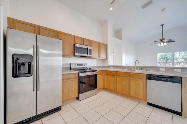 kitchen featuring ceiling fan, sink, high vaulted ceiling, light tile patterned flooring, and appliances with stainless steel finishes