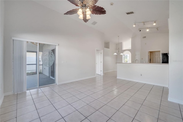 empty room featuring ceiling fan, light tile patterned floors, and high vaulted ceiling