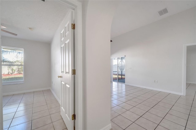 hall with light tile patterned floors and a textured ceiling