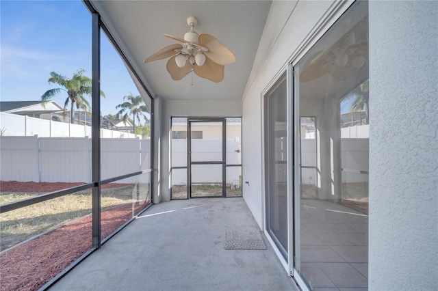 unfurnished sunroom with ceiling fan