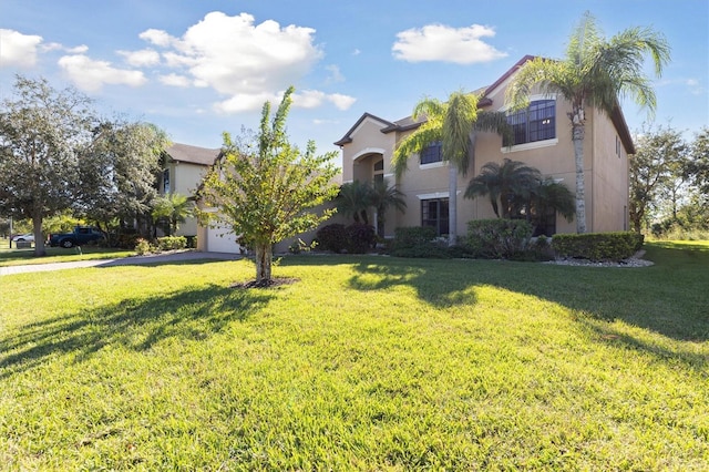 mediterranean / spanish home featuring a garage and a front lawn