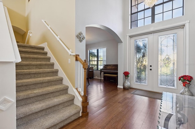 foyer entrance with french doors, dark hardwood / wood-style floors, and a high ceiling