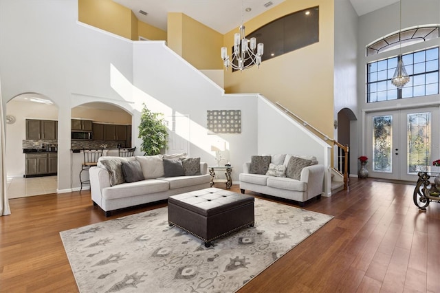 living room featuring a high ceiling, hardwood / wood-style flooring, and french doors