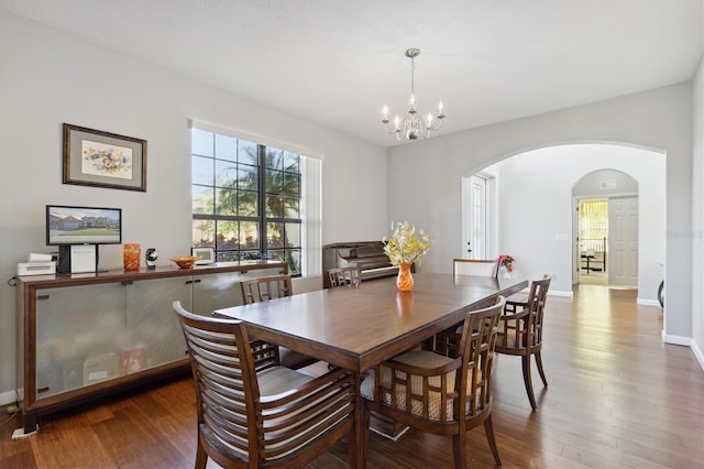 dining area featuring dark hardwood / wood-style floors and an inviting chandelier