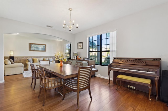 dining space with dark hardwood / wood-style floors and an inviting chandelier