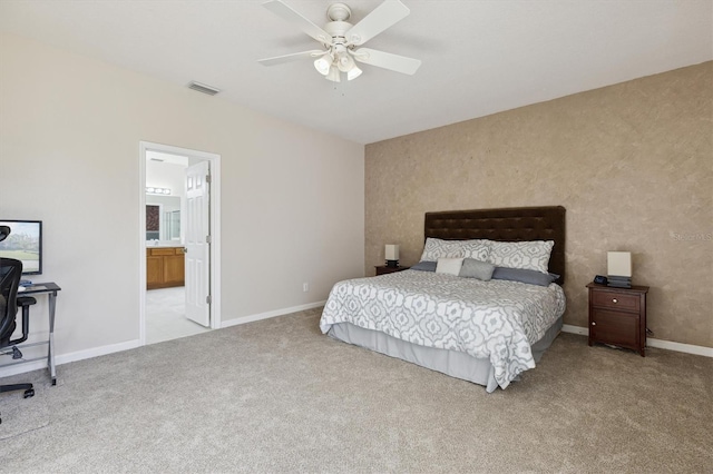 bedroom with ceiling fan, light carpet, and connected bathroom