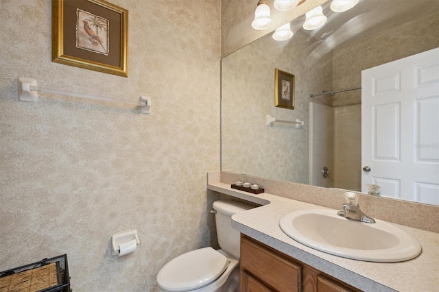 bathroom with vanity, toilet, and walk in shower