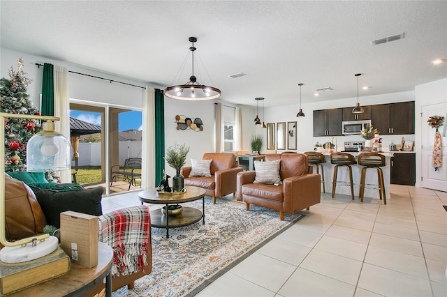 tiled living room with a textured ceiling and a chandelier