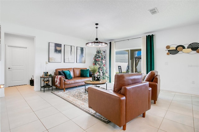 living room with a textured ceiling, an inviting chandelier, and light tile patterned flooring