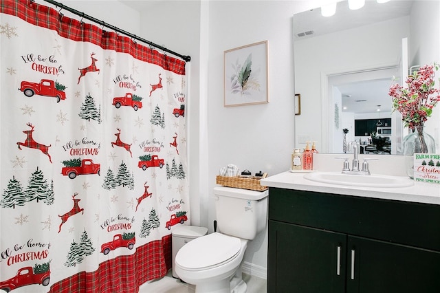 bathroom with curtained shower, vanity, and toilet