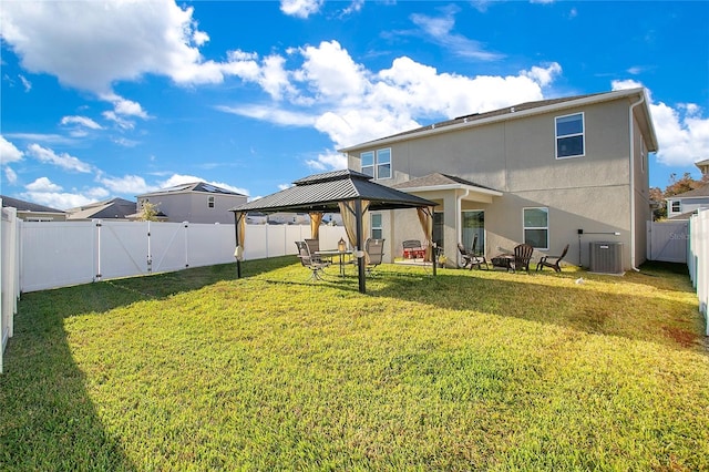 rear view of house with a gazebo, central air condition unit, and a lawn