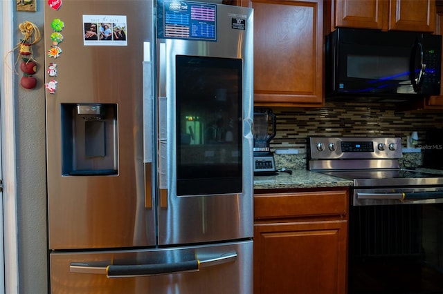 kitchen featuring light stone countertops, backsplash, and stainless steel appliances