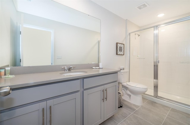 bathroom featuring tile patterned floors, a shower with door, vanity, and toilet