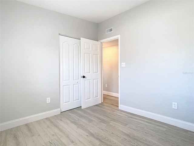 unfurnished bedroom with a closet and light hardwood / wood-style floors