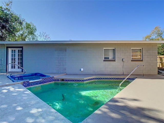 view of swimming pool with an in ground hot tub, french doors, and a patio