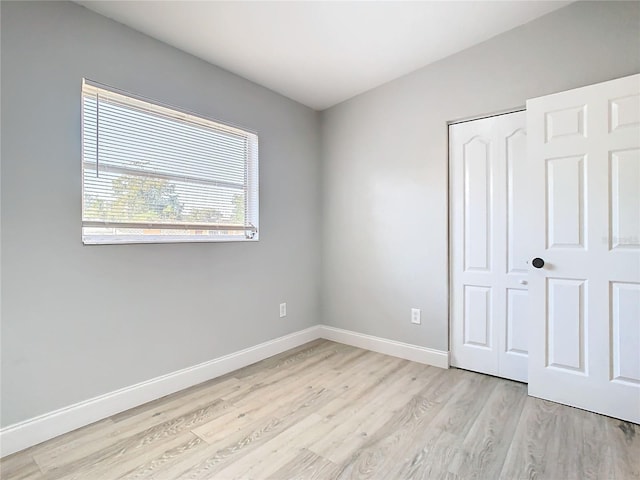 unfurnished bedroom with light hardwood / wood-style floors and a closet