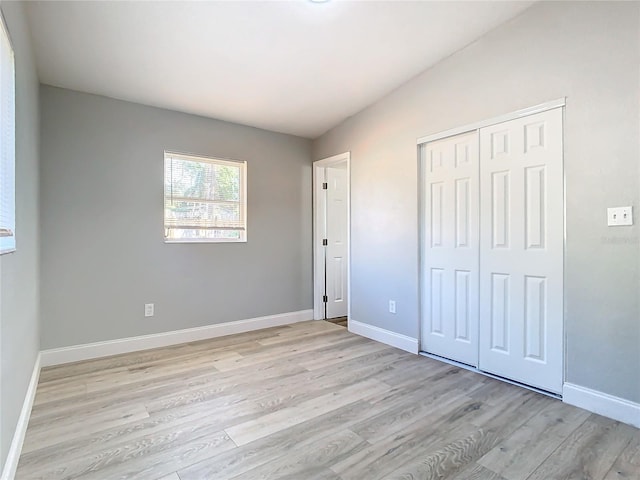 unfurnished bedroom with a closet and light hardwood / wood-style flooring