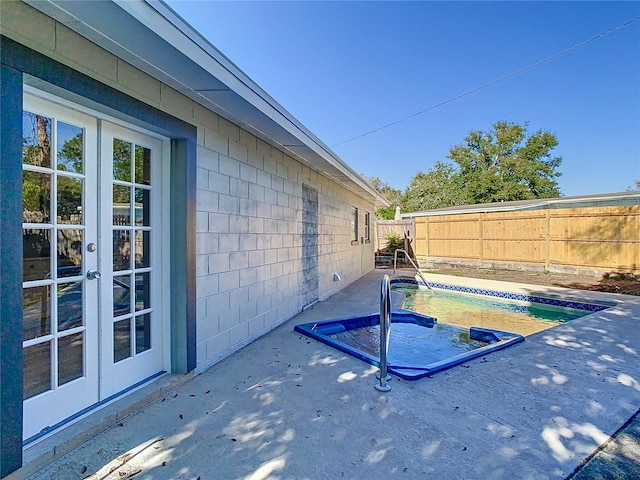 view of swimming pool featuring a patio and french doors