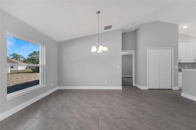 interior space featuring tile patterned floors, lofted ceiling, and a notable chandelier