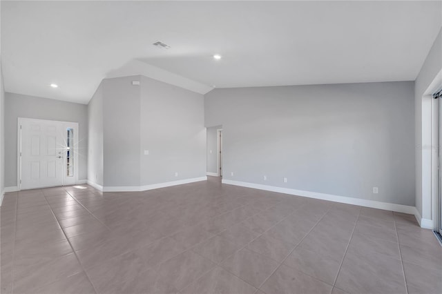 unfurnished living room with light tile patterned floors and vaulted ceiling