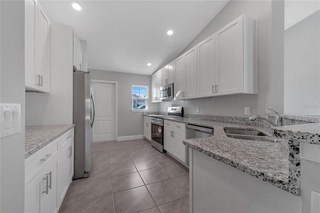 kitchen featuring white cabinetry, sink, light stone counters, and appliances with stainless steel finishes