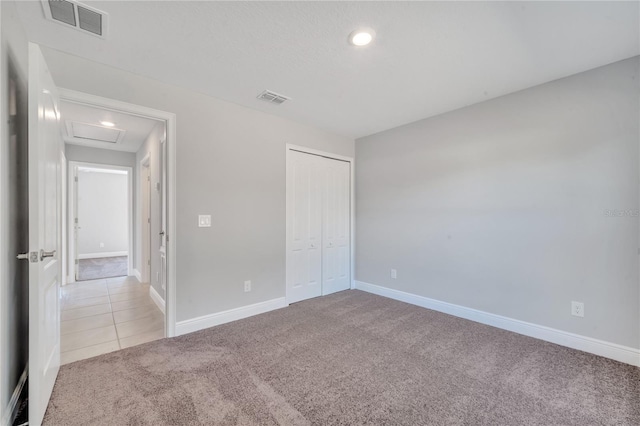 unfurnished bedroom with light carpet and a closet