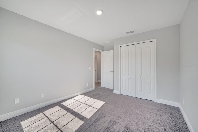 unfurnished bedroom featuring carpet flooring and a closet