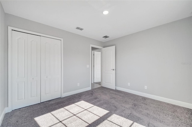 unfurnished bedroom featuring carpet flooring and a closet