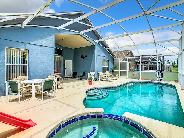 view of swimming pool with a lanai, a patio area, and an in ground hot tub