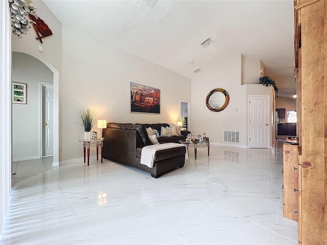 living room featuring a textured ceiling and vaulted ceiling