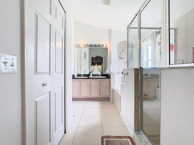 bathroom featuring tile patterned flooring, vanity, independent shower and bath, and vaulted ceiling