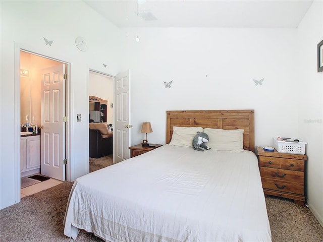 bedroom featuring carpet, connected bathroom, and vaulted ceiling