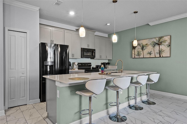 kitchen with gray cabinetry, a breakfast bar, an island with sink, and black appliances