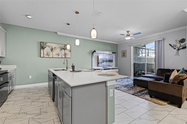 kitchen featuring pendant lighting, gray cabinetry, ornamental molding, and a kitchen island with sink