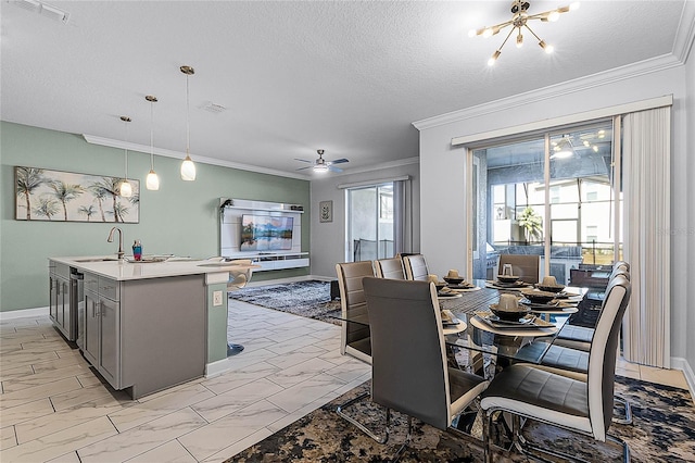 dining area with ceiling fan with notable chandelier, sink, ornamental molding, and a textured ceiling