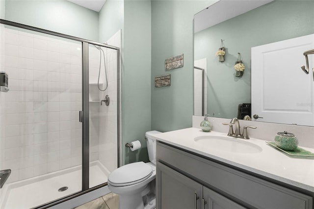 bathroom with tile patterned flooring, vanity, toilet, and a shower with shower door