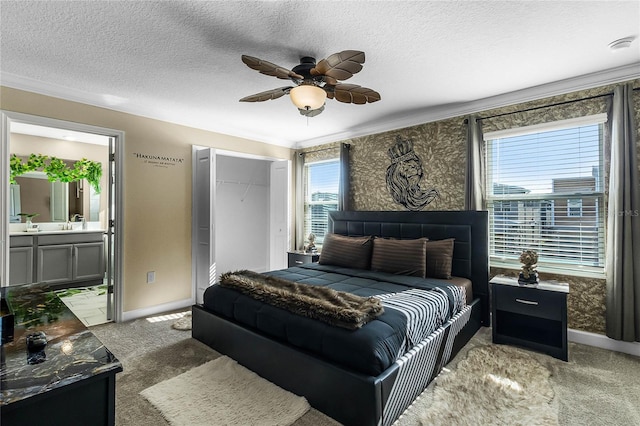 carpeted bedroom with ornamental molding, a textured ceiling, ceiling fan, connected bathroom, and a closet