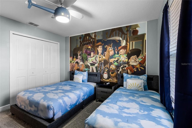 carpeted bedroom featuring ceiling fan and a closet