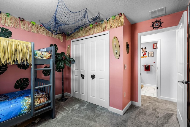 carpeted bedroom with a closet and a textured ceiling