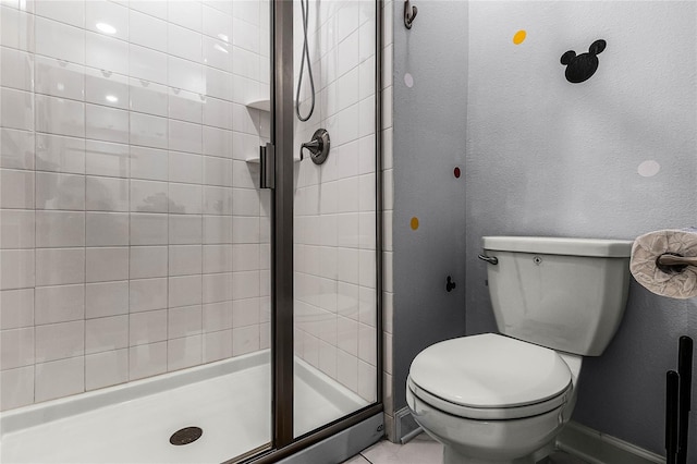 bathroom featuring toilet and a shower with door