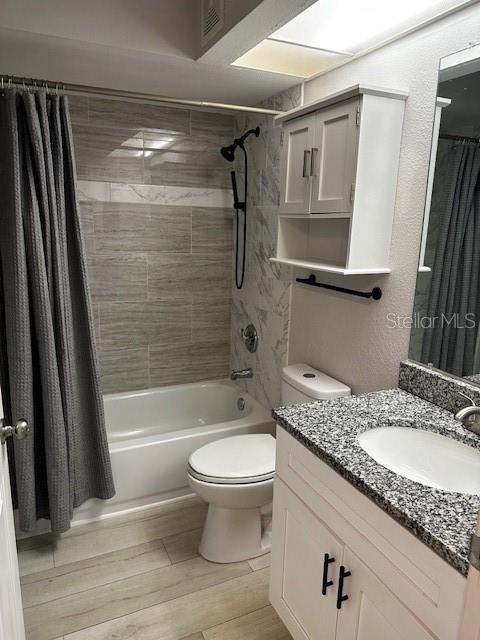 full bathroom with shower / tub combo, vanity, and toilet