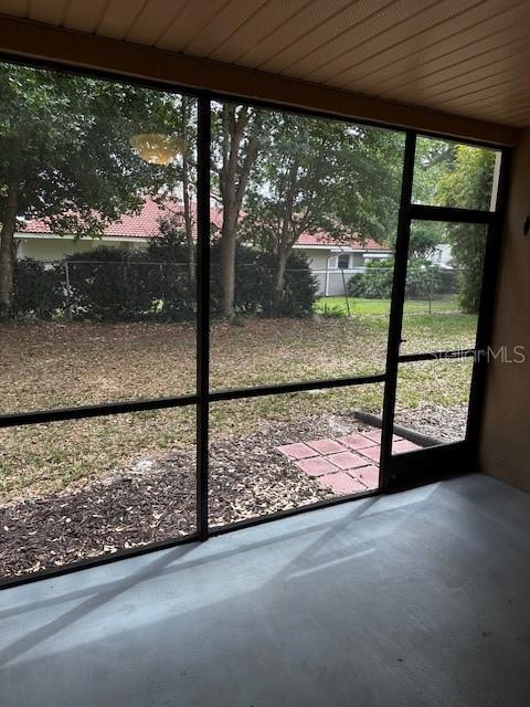 doorway with concrete flooring and wood ceiling