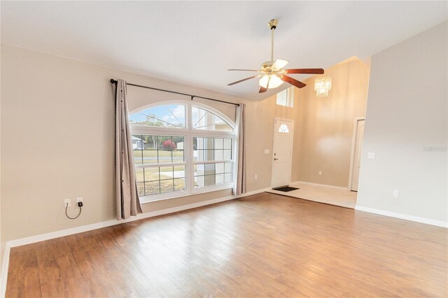 spare room with high vaulted ceiling, hardwood / wood-style floors, and ceiling fan