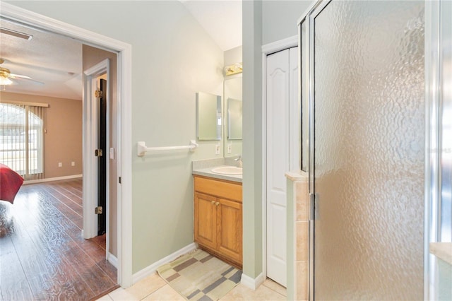 bathroom featuring vanity, hardwood / wood-style flooring, ceiling fan, and walk in shower