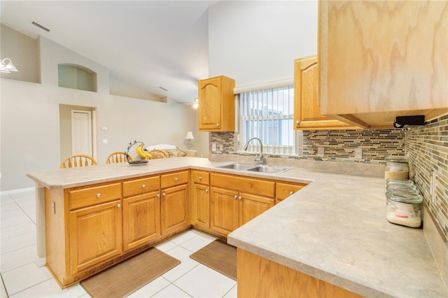 kitchen with sink, backsplash, kitchen peninsula, and light tile patterned flooring