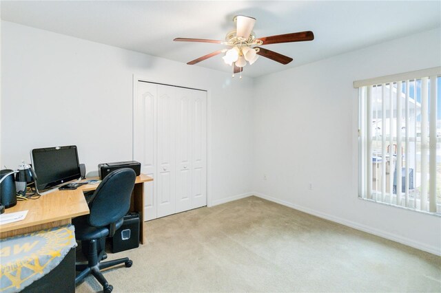 carpeted office space with ceiling fan