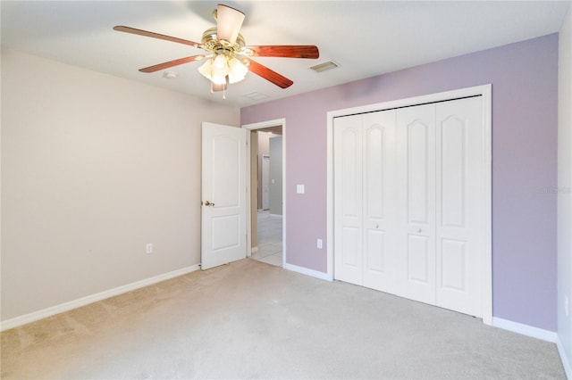 unfurnished bedroom with light colored carpet, ceiling fan, and a closet