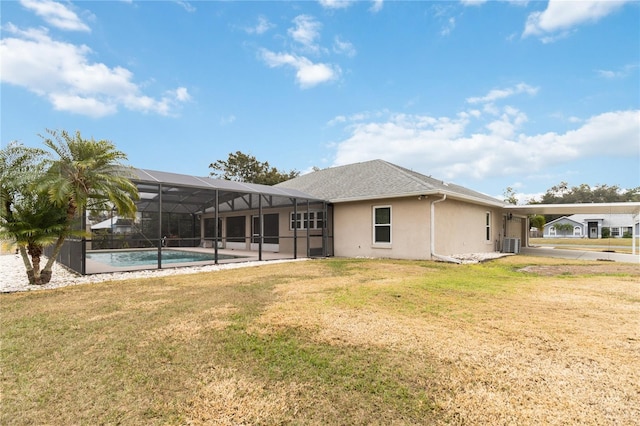 back of house with a yard, a lanai, and central AC unit