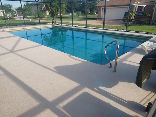 view of swimming pool with a lanai, a lawn, and a patio area